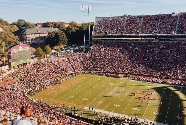 A large open air football stadium with the seats packed to the brim with fans